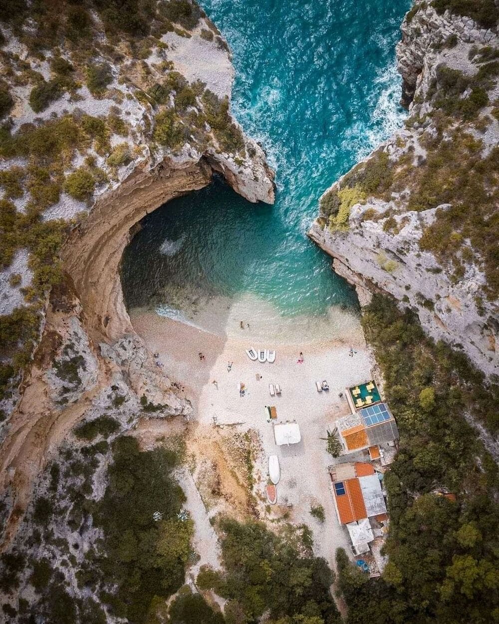 Stiniva cove from above — a hidden beach walled by limestone cliffs